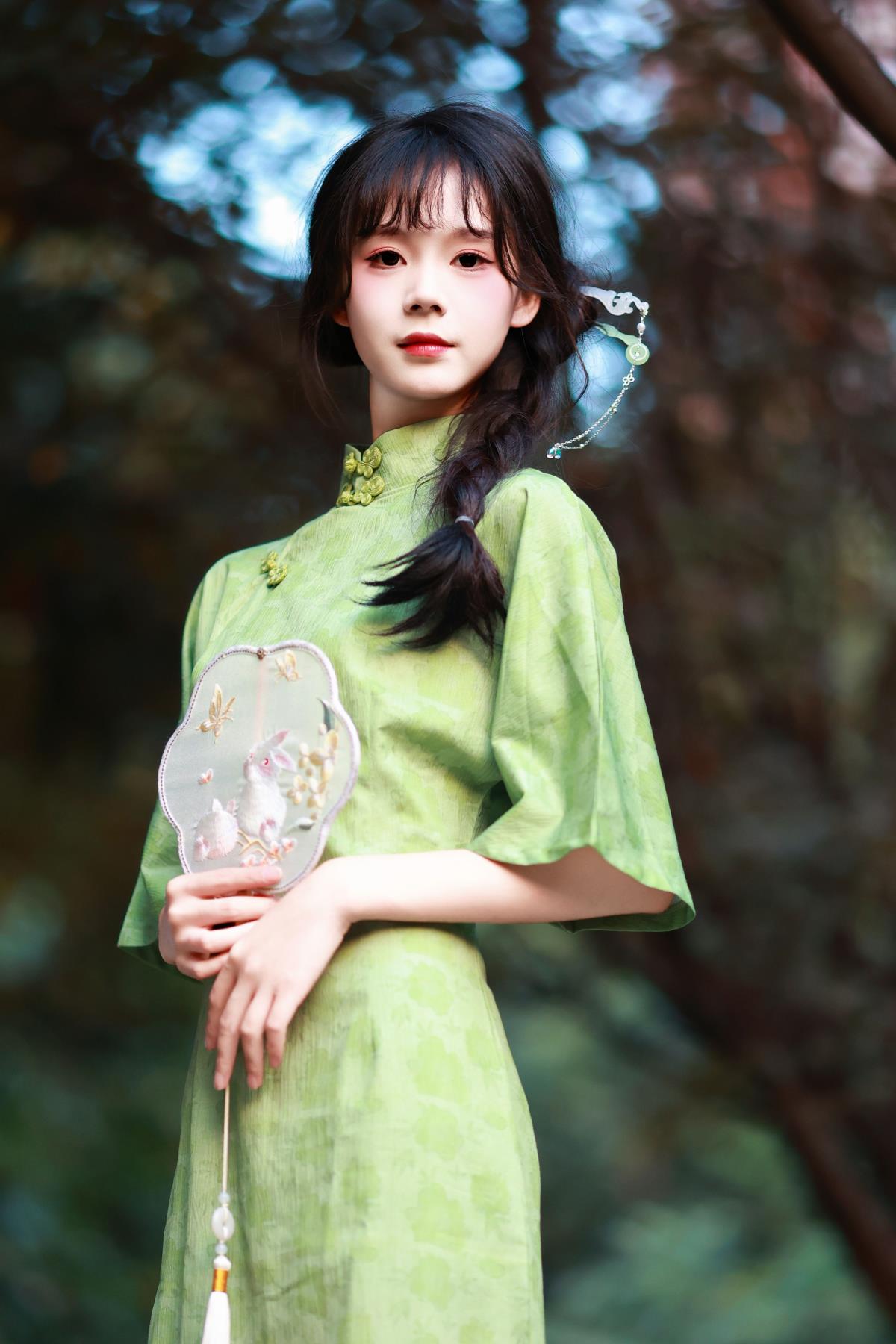 《绿罗裙下，油纸伞与旗袍美人的林间漫步》 或 《林间，旗袍美人撑着油纸伞，绿罗裙拂过清寒》 或 《风吹发梢，旗袍美人撑油纸伞于林间，绿罗裙韵》