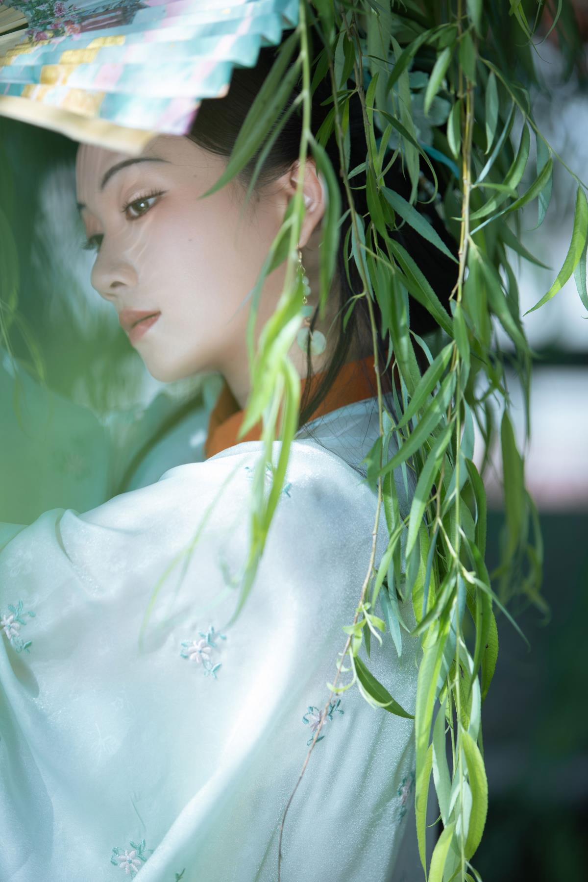 绿柳亭前风细细，罗衣轻扇自生香